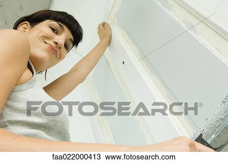 Woman painting door with paint roller, smiling at camera, low angle view View Large Photo Image Stock Image - Woman painting door with paint roller, smiling at camera, low angle view. Fotosearch