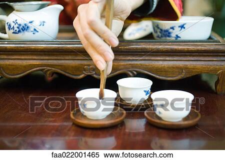 Stock Photography - Woman preparing tea, cropped view of hand. Fotosearch