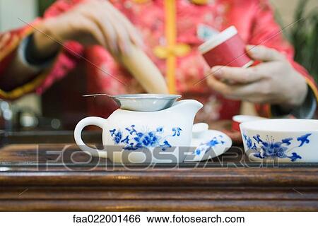 Stock Photograph - Woman preparing tea, cropped view. Fotosearch