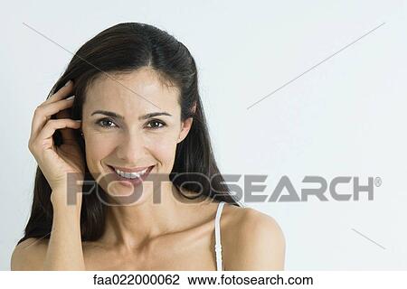 Woman, pushing hair back, smiling at camera, portrait View Large Photo Image Stock Image - Woman, pushing hair back, smiling at camera, portrait. Fotosearch