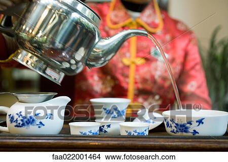 Woman serving tea, cropped view View Large Photo Image Picture - Woman serving tea, cropped view. Fotosearch