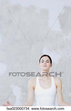 Woman sitting in lotus position, eyes closed, waist up View Large Photo Image Picture - Woman sitting in lotus position, eyes closed, waist up. Fotosearch