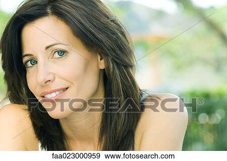 Stock Photo - Woman smiling at camera, head tilted, portrait. Fotosearch