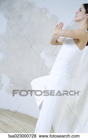 Stock Photo - Woman standing in tree pose, side view. Fotosearch