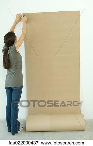 Woman stapling corrugated cardboard to wall View Large Photo Image Stock Photo - Woman stapling corrugated cardboard to wall. Fotosearch