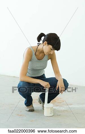 Stock Photograph - Woman stirring paint product. Fotosearch