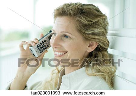 Woman using cell phone, smiling, portrait View Large Photo Image Stock Image - Woman using cell phone, smiling, portrait. Fotosearch