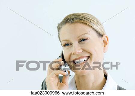 Stock Photograph - Woman using cell phone, smiling, portrait. Fotosearch