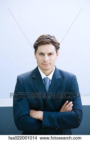 Young businessman, arms folded, looking at camera, portrait View Large Photo Image Picture - Young businessman, arms folded, looking at camera, portrait. Fotosearch