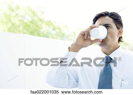 Young businessman drinking hot beverage, close-up View Large Photo Image Stock Photography - Young businessman drinking hot beverage, close-up. Fotosearch