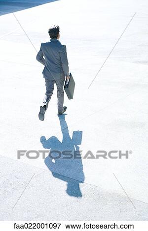 Young businessman running outdoors, carrying briefcase, full length, rear view View Large Photo Image Stock Photo - Young businessman running outdoors, carrying briefcase, full length, rear view. Fotosearch