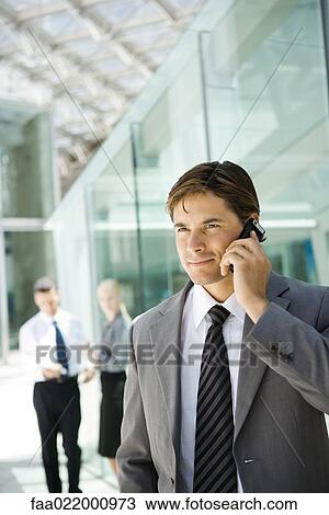 Young businessman using cell phone, looking away, portrait View Large Photo Image Stock Image - Young businessman using cell phone, looking away, portrait. Fotosearch
