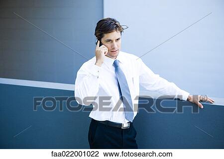 Young businessman using cell phone, waist up View Large Photo Image Stock Image - Young businessman using cell phone, waist up. Fotosearch