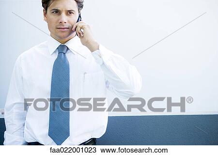 Young businessman using cell phone, looking away, close-up View Large Photo Image Stock Image - Young businessman using cell phone, looking away, close-up. Fotosearch