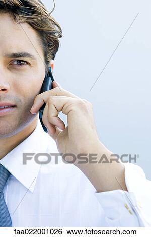 Young businessman using cell phone, cropped view, close-up View Large Photo Image Stock Photograph - Young businessman using cell phone, cropped view, close-up. Fotosearch