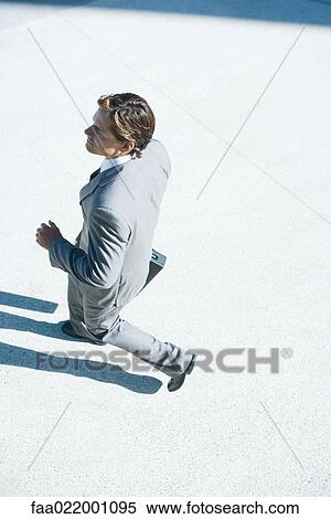 Young businessman walking outdoors, high angle view View Large Photo Image Stock Photography - Young businessman walking outdoors, high angle view. Fotosearch