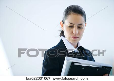 Young businesswoman looking at file, head and shoulders View Large Photo Image Stock Photo - Young businesswoman looking at file, head and shoulders. Fotosearch