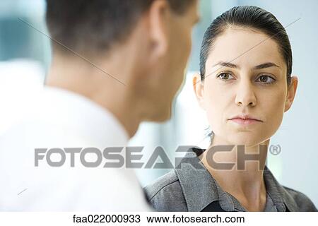 Young businesswoman looking away, associate in foreground View Large Photo Image Stock Image - Young businesswoman looking away, associate in foreground. Fotosearch