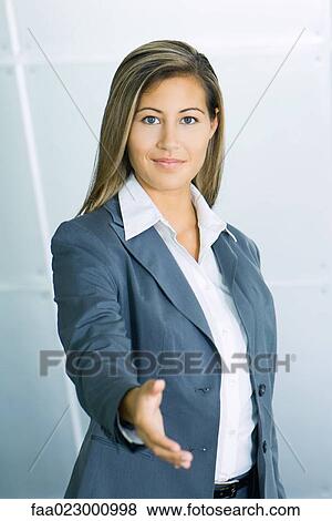 Young businesswoman smiling and holding out hand to camera, portrait View Large Photo Image Stock Photo - Young businesswoman smiling and holding out hand to camera, portrait. Fotosearch