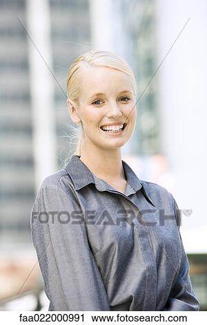Young businesswoman smiling at camera, waist up, portrait View Large Photo Image Stock Image - Young businesswoman smiling at camera, waist up, portrait. Fotosearch
