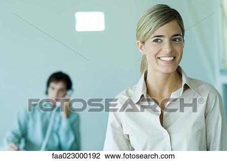 Young businesswoman smiling in office, portrait View Large Photo Image Stock Image - Young businesswoman smiling in office, portrait. Fotosearch