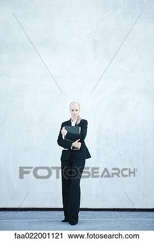 Young businesswoman standing, arms folded, looking at camera, full length View Large Photo Image Stock Image - Young businesswoman standing, arms folded, looking at camera, full length. Fotosearch