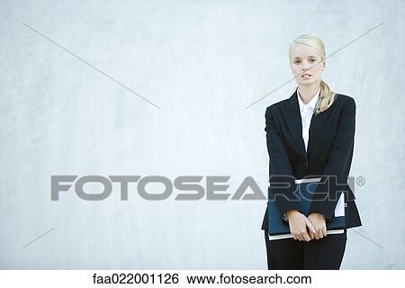 Young businesswoman standing, looking at camera, three quarter length View Large Photo Image Stock Photograph - Young businesswoman standing, looking at camera, three quarter length. Fotosearch