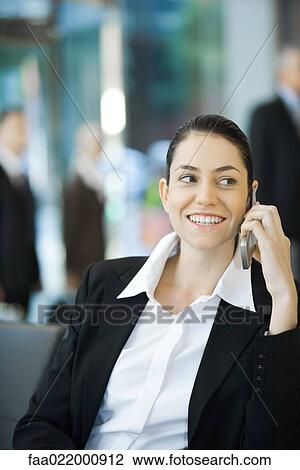 Young businesswoman using cell phone, smiling, waist up View Large Photo Image Stock Image - Young businesswoman using cell phone, smiling, waist up. Fotosearch