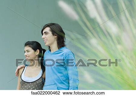 Stock Image - Young couple, focus on background. Fotosearch