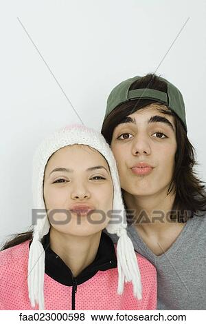 Young couple looking at camera, cheek to cheek, both puckering, portrait View Large Photo Image Stock Photo - Young couple looking at camera, cheek to cheek, both puckering, portrait. Fotosearch