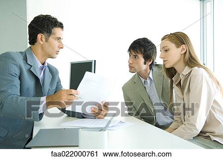 Young couple sitting across desk from businessman, businessman explaining document View Large Photo Image Stock Image - Young couple sitting across desk from businessman, businessman explaining document. Fotosearch