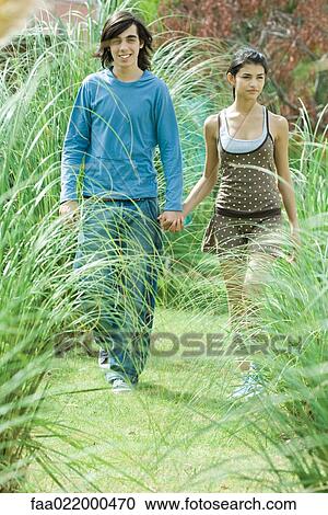 Young couple walking through long grasses of ornamental garden View Large Photo Image Stock Image - Young couple walking through long grasses of ornamental garden. Fotosearch