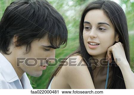 Young couple, woman looking at man, man looking down, head and shoulders View Large Photo Image Stock Image - Young couple, woman looking at man, man looking down, head and shoulders. Fotosearch