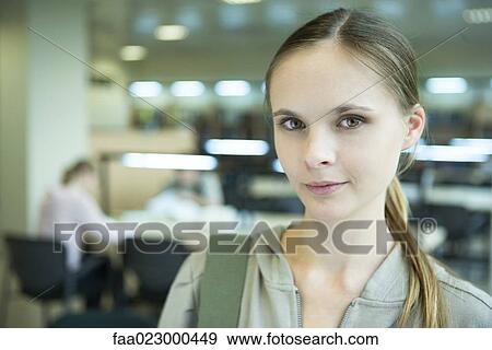 Young female college student in library, looking at camera, head and shoulders View Large Photo Image Stock Photo - Young female college student in library, looking at camera, head and shoulders. Fotosearch