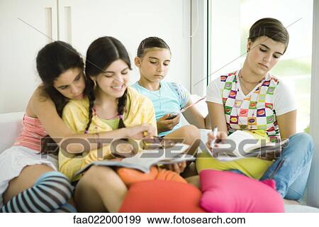 Young female friends doing homework together View Large Photo Image Stock Photo - Young female friends doing homework together. Fotosearch