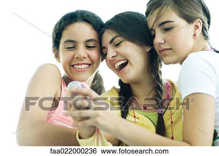 Young female friends looking at cell phone together, laughing View Large Photo Image Stock Photograph - Young female friends looking at cell phone together, laughing. Fotosearch