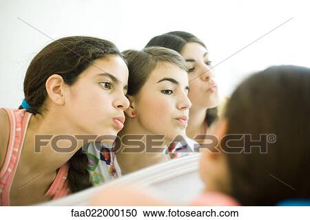 Young female friends looking at mirror, puckering View Large Photo Image Stock Image - Young female friends looking at mirror, puckering. Fotosearch