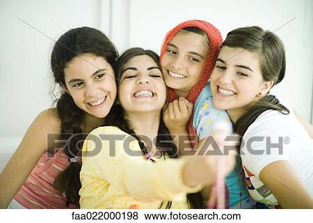 Young female friends posing for photo together View Large Photo Image Stock Photo - Young female friends posing for photo together. Fotosearch
