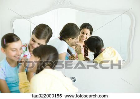 Young female friends putting make-up on younger girl View Large Photo Image Stock Photography - Young female friends putting make-up on younger girl. Fotosearch