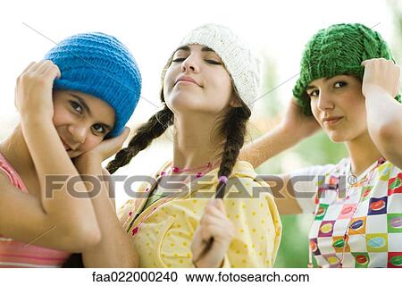 Young female friends wearing knit hats, looking at camera View Large Photo Image Stock Image - Young female friends wearing knit hats, looking at camera. Fotosearch