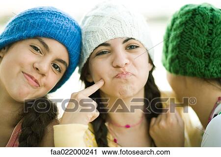 Young female friends wearing knit hats, making faces View Large Photo Image Stock Image - Young female friends wearing knit hats, making faces. Fotosearch