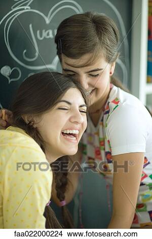 Young female friends writing names in hearts on chalkboard, laughing View Large Photo Image Picture - Young female friends writing names in hearts on chalkboard, laughing. Fotosearch