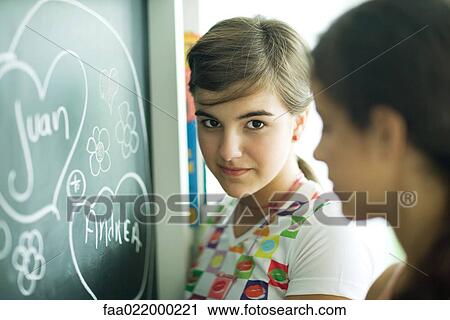 Young female friends writing names in hearts on chalkboard View Large Photo Image Stock Image - Young female friends writing names in hearts on chalkboard. Fotosearch