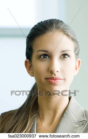 Young female in business attire smiling, looking up, portrait View Large Photo Image Stock Photo - Young female in business attire smiling, looking up, portrait. Fotosearch