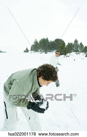 Young friends having snowball fight in snow View Large Photo Image Stock Photo - Young friends having snowball fight in snow. Fotosearch
