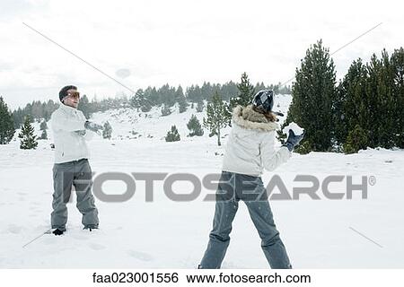 Stock Photograph - Young friends having snowball fight. Fotosearch