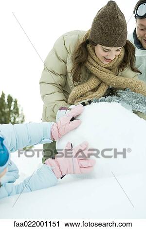 Young friends in snow, making snowball together, cropped view View Large Photo Image Stock Image - Young friends in snow, making snowball together, cropped view. Fotosearch