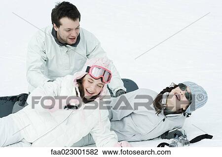 Young friends playing around in snow, laughing View Large Photo Image Stock Image - Young friends playing around in snow, laughing. Fotosearch