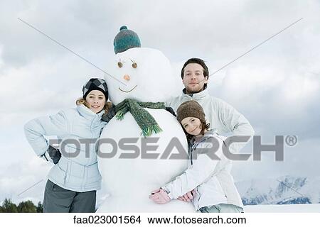 Young friends posing next to snowman, portrait View Large Photo Image Picture - Young friends posing next to snowman, portrait. Fotosearch