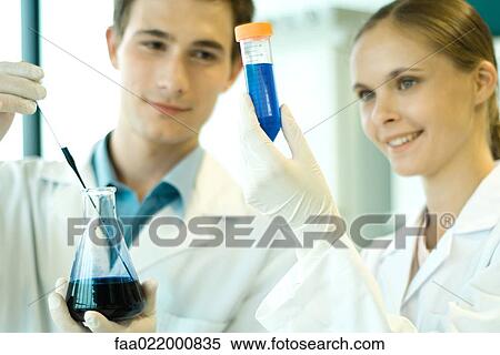 Young male and female scientists holding test tube and flask View Large Photo Image Stock Photography - Young male and female scientists holding test tube and flask. Fotosearch
